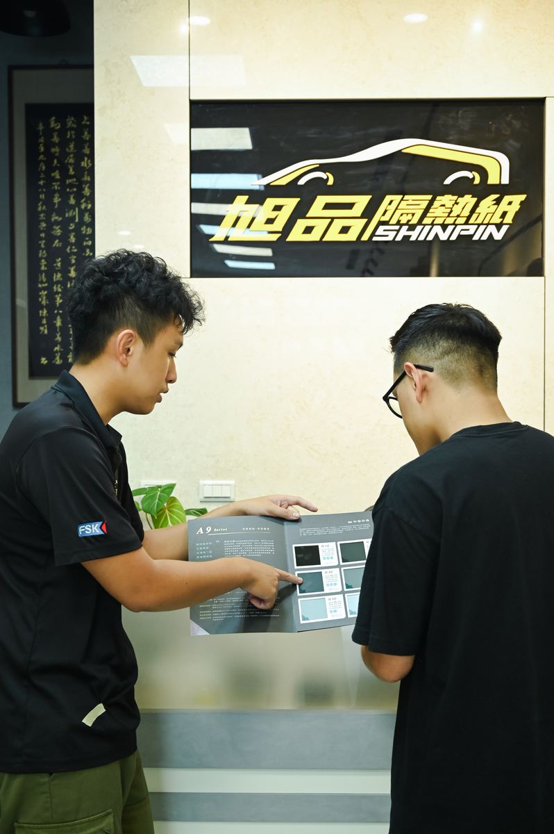 師傅拿樣品冊向客人說明膜款